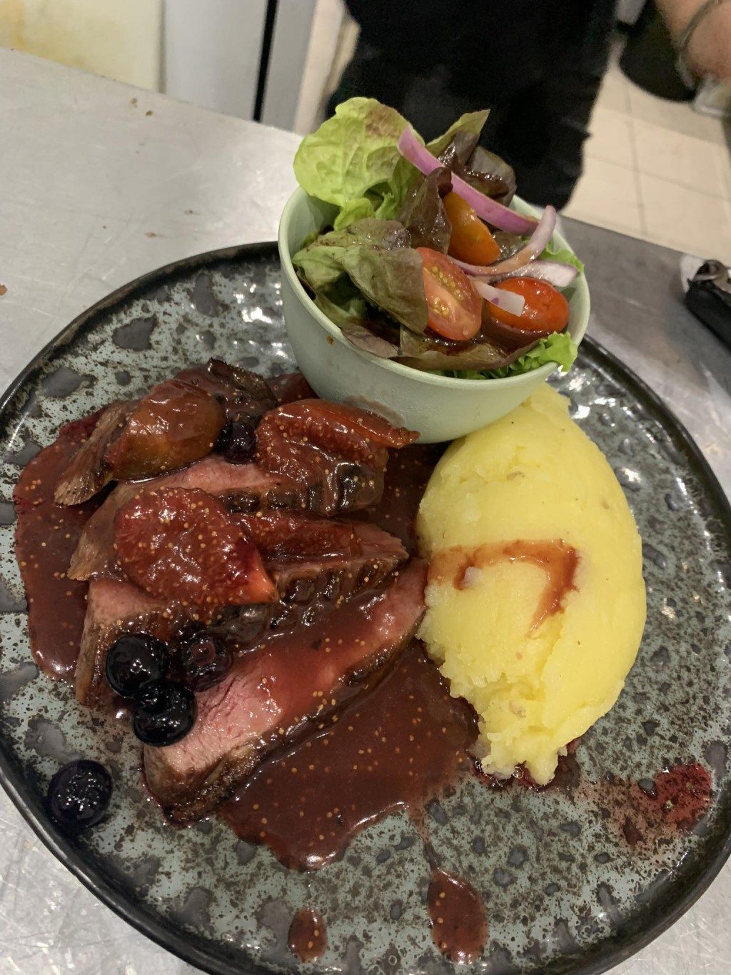 Un magret de canard avec une purée dorée et une sauce